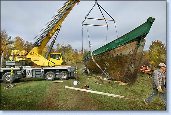 A large crane lifts her off the trailer