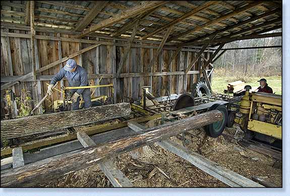 This shows Vern on the mill postioning the ash log, note the pine log in the foreground.