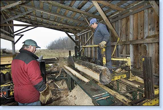 This shows Vern on the mill postioning the ash log, note the pine log in the foreground.